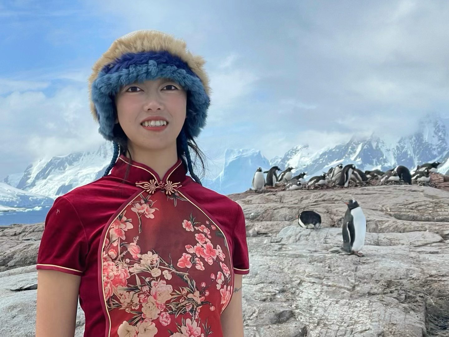 Hayley con qipao en la Antártida, junto a pingüinos